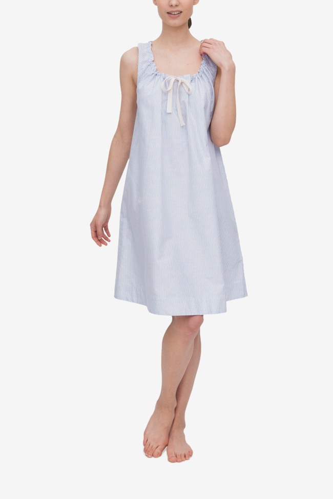 Front view of the Sleeveless Nightie in Blue Oxford Stripe. The model has one arm at her side and the other hand up at the shoulder, highlighting the gathered neckline.