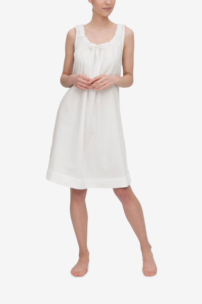 Front view of the Sleeveless Nightie, it's knee length and has a unique gathered necking with the bow tied at centre front. Shown here in a classic white royal oxford shirting, a fabric with great texture and drape.