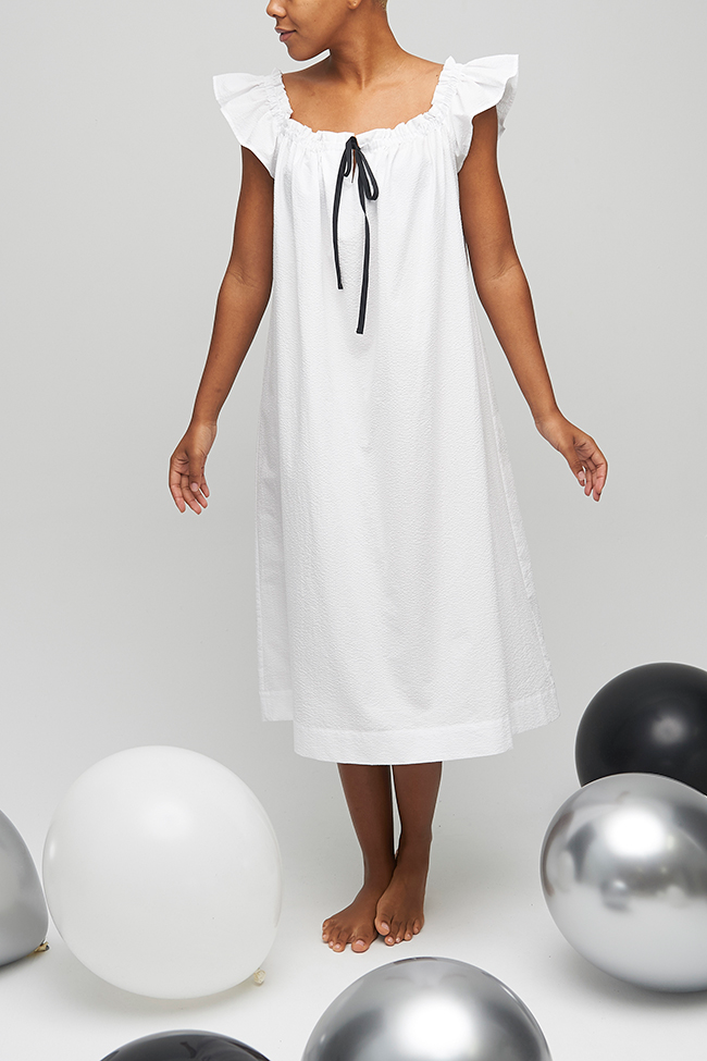 A below-the-knee length nightdress with short flounce sleeves and gathered neckline. Made in a classic seersucker cotton in white. 