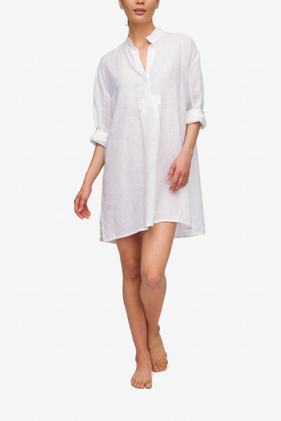 Front view of the White Linen Short Sleep Shirt, its full length sleeves are folded up to the elbow. The placket has 2 or 3 buttons open for an effortless look.