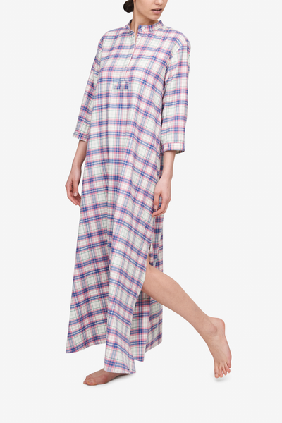 Woman wearing a full length flannel nightshirt with a pink check pattern