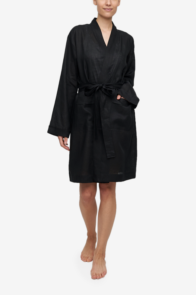 Unisex black linen robe with two patch pockets and matching belt. Knee length on most with ling sleeves. 