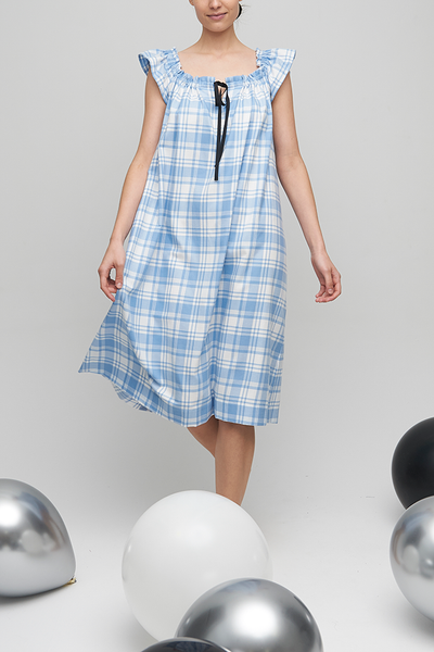 A slightly below the knee length nightdress in a super soft blue and white plaid flannel. It has black grosgrain ribbon around the neckline that can be gathered as much or as little as you like. 