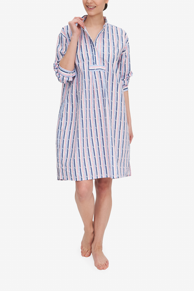 A woman grabs the collar of her Long Sleep Shirt to show the placket and collar details. It's made from a custom pink and blue geometric stripe, printed on a lightweight, white cotton shirting. 