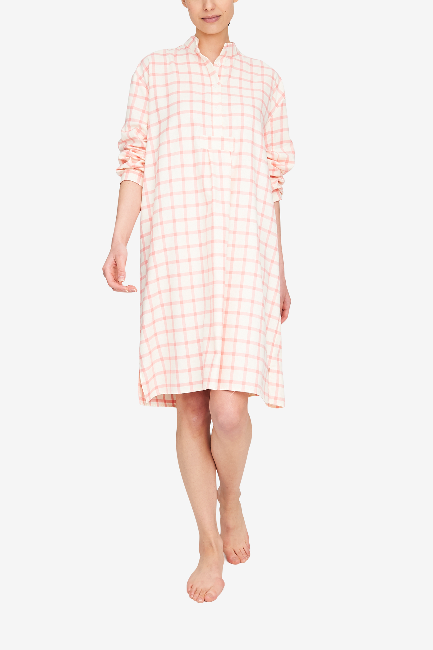 Woman wearing a cream and pink check sleep shirt made in the softest flannel. Long sleeves,  knee length, stand collar.