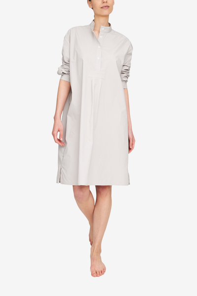 The Long Sleep Shirt in a crisp, smooth shirting in a light grey colour. Design details are a stand collar, three quarter placket, and full length sleeves that look great pushed up to the elbow.