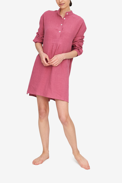 Our model Emily stands in front of a white background, wearing the Short Sleep Shirt. This version is made from a bouncy, lightweight washed linen in a deep, rose pink colour. 