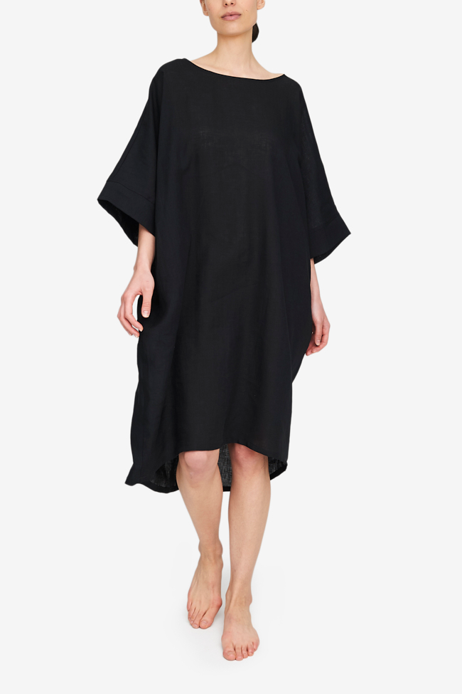 Full body shot of the Pocket Kaftan in our favourite - black linen. A wide boat neck, big, wide elbow length sleeves and a cocoon silhouette. A slight high-low hem makes this piece modern and easy to wear.