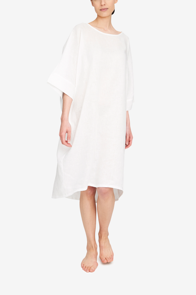 A stunning knee-length dress, shown here in white linen, with a slight high-low hem line. The Pocket Kaftan has a cocoon shape, a boat neck and wide, elbow length sleeves. 