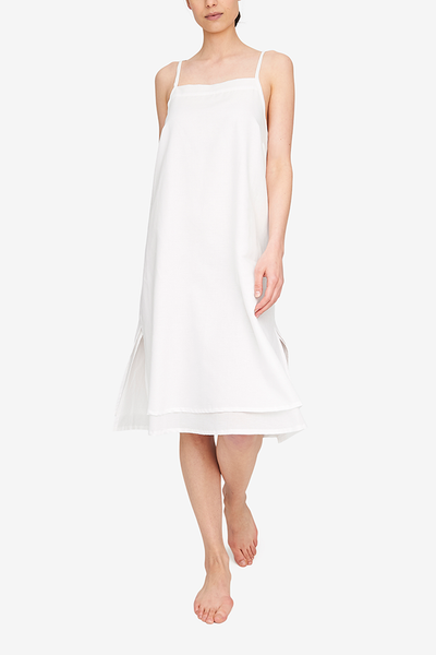 Front view of the Two Layer Dress, shown here in our lightweight, white Milano cotton/linen blend. The dress has a square neckline, spaghetti straps that cross in the back and a double layer body with different hem lengths - the outer layer is a couple inches shorter. Side slits make this shape sway and move when being worn.